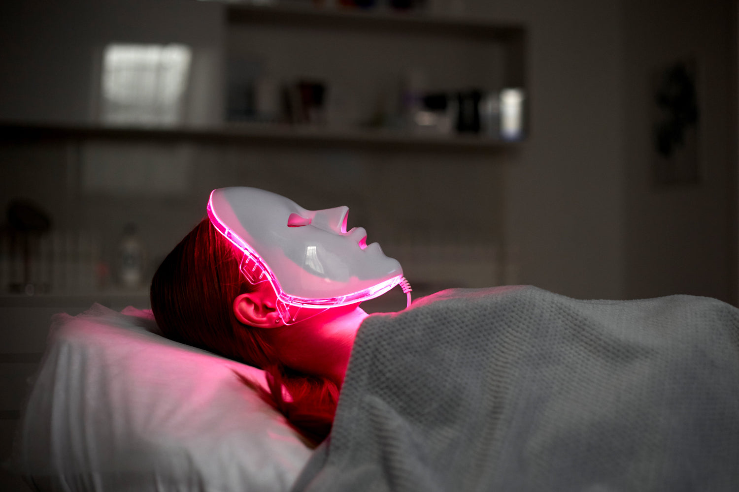 LED light therapy mask emitting red light during a skin rejuvenation session, used for collagen stimulation, acne treatment, and facial recovery benefits.